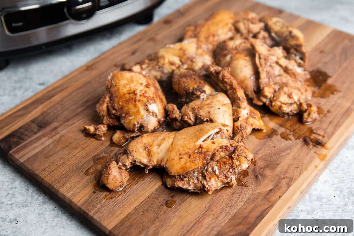 Slow-Cooker Shredded Chipotle Chicken Recipe for Tacos & Bowls 7 chicken thighs on a cutting board