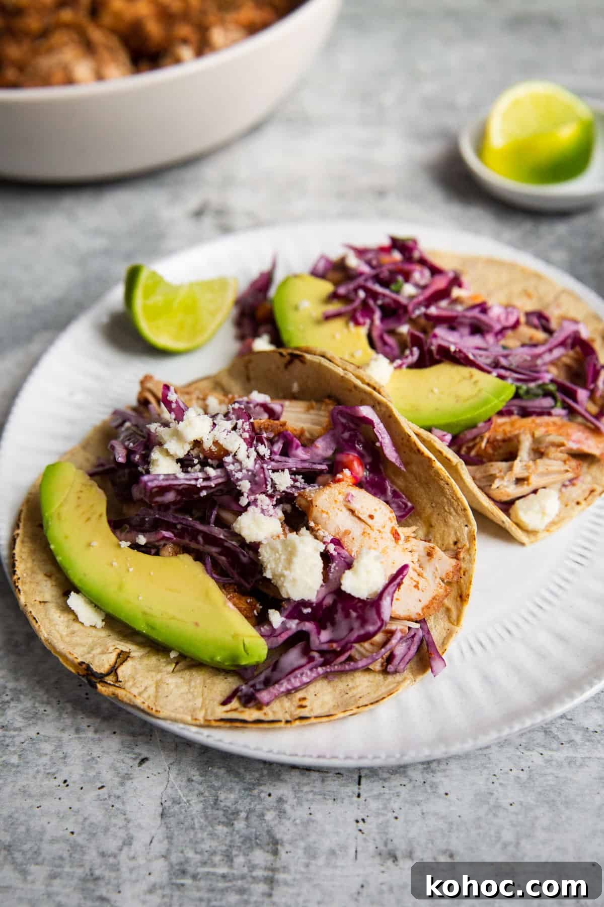Slow-Cooker Shredded Chipotle Chicken Recipe for Tacos & Bowls 9 a close up photo of this chipotle chicken recipe shredded and stuffed into tacos