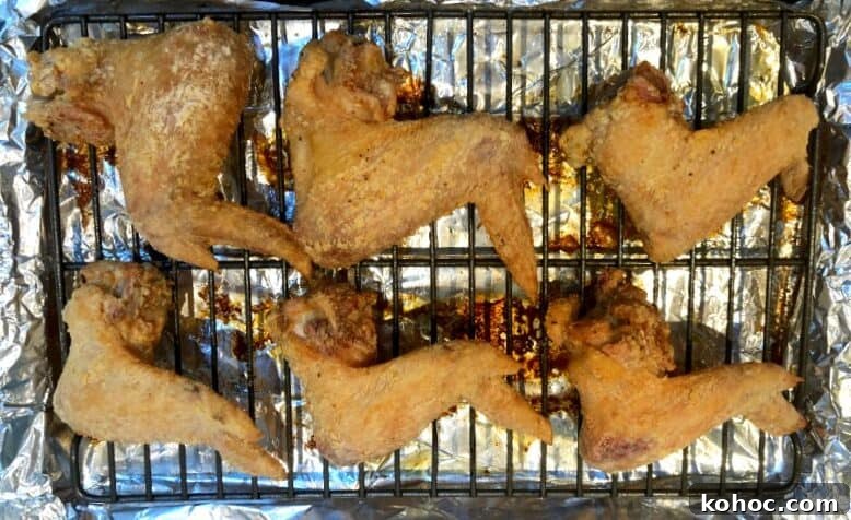 Crispy Oven-Baked Asian-Style Chicken Wings for Game Night 6 baked chicken wings on rack.