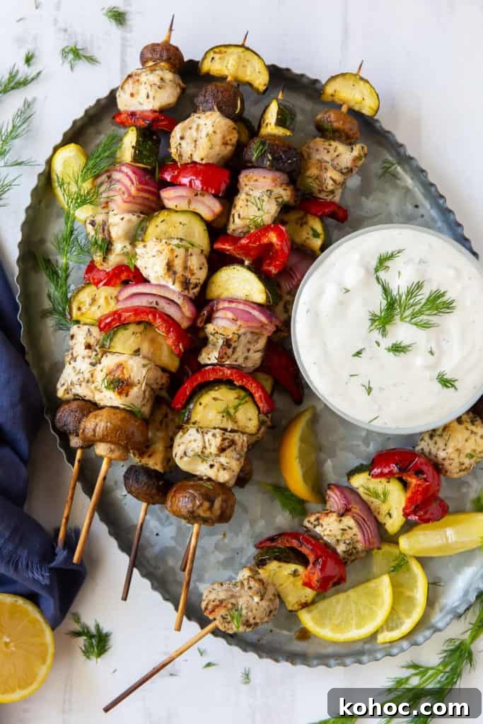 Greek Chicken Kabobs Recipe with Tzatziki and Grilled Vegetables 11 Greek Chicken Kabobs on a silver platter with Feta Dill Sauce.