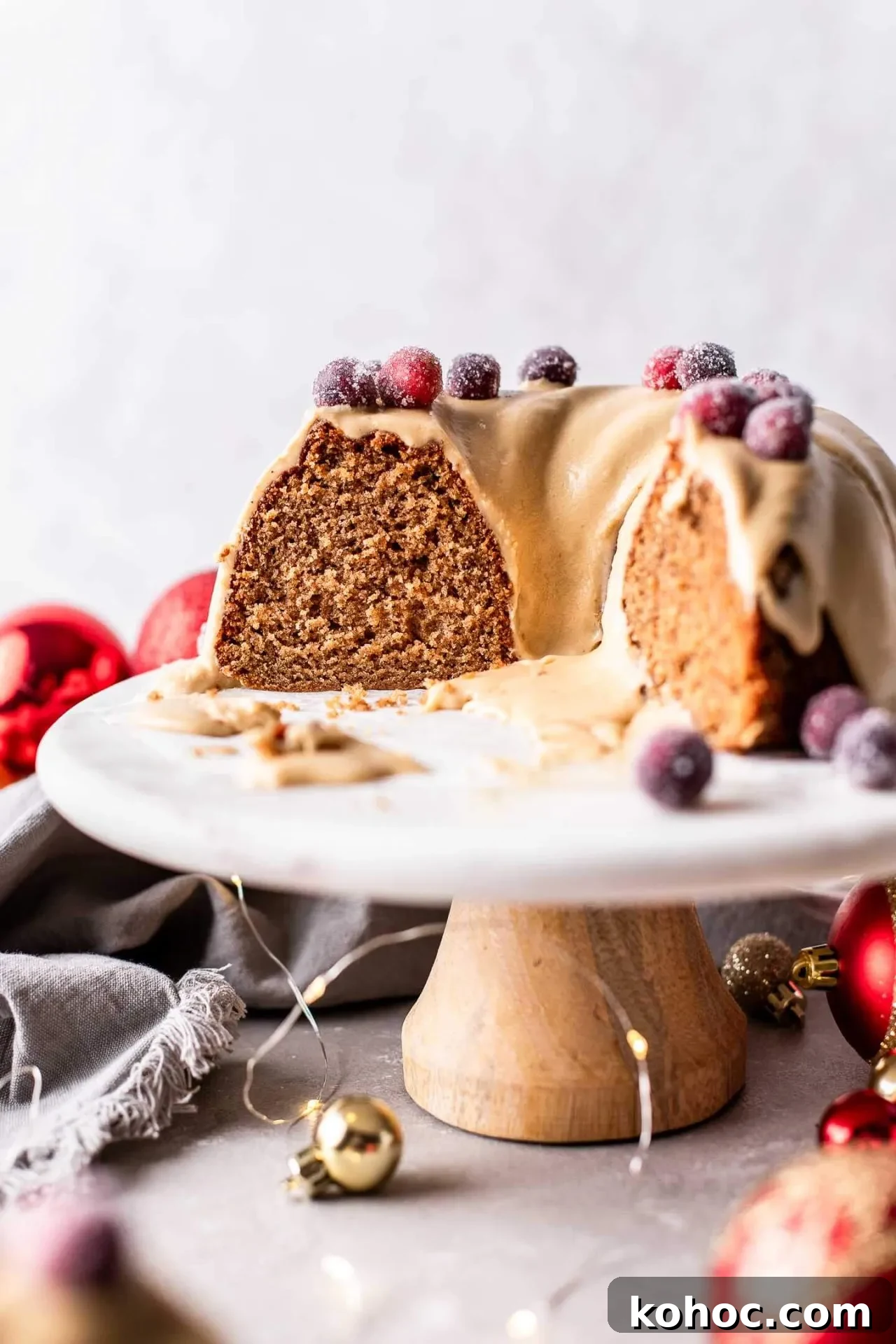 Caramel Gingerbread Cake with Silky Whipped Caramel Icing 13 frosted caramel gingerbread cake decorated with sugared cranberries on cake stand (7)