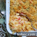 A casserole dish of baked macaroni and cheese made with pimento cheese and a ritz cracker crust.