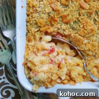A casserole dish of baked macaroni and cheese made with pimento cheese and a ritz cracker crust.