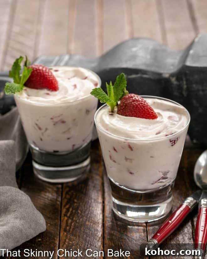 2 dishes of strawberry fool garnished with a half strawberry and mint sprig