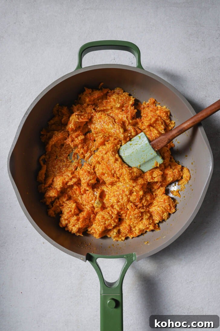 Cooking down carrot mixture in final stages to make Carrot Halwa.