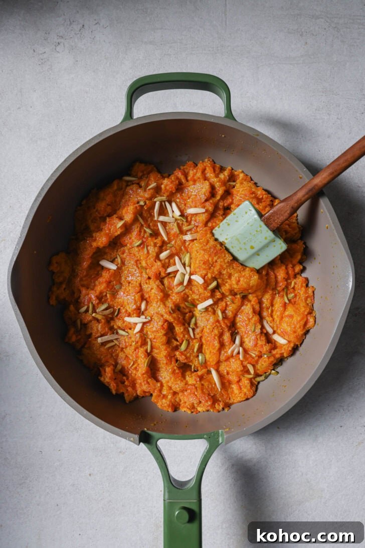 Carrot Halwa in a skillet garnished with slivered almonds.