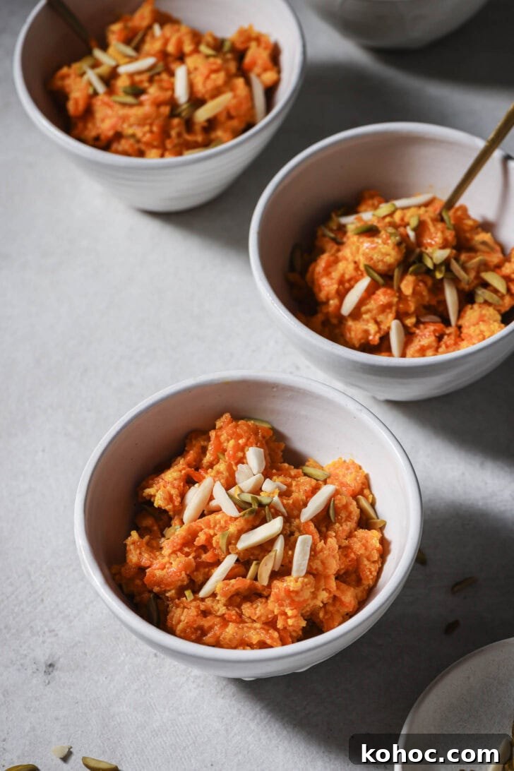 Close up of bowls of Carrot Halwa garnished with slivered almonds and pistachios ready to be eaten.