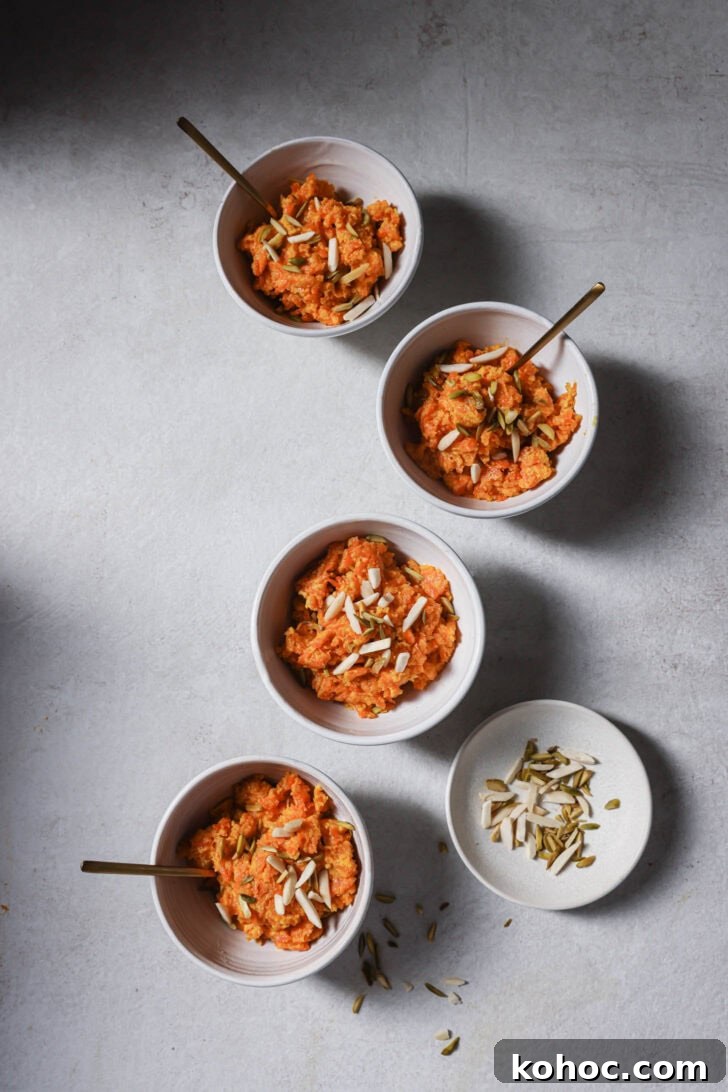 Bowls of Carrot Halwa garnished with slivered almonds and pistachios ready to be eaten.