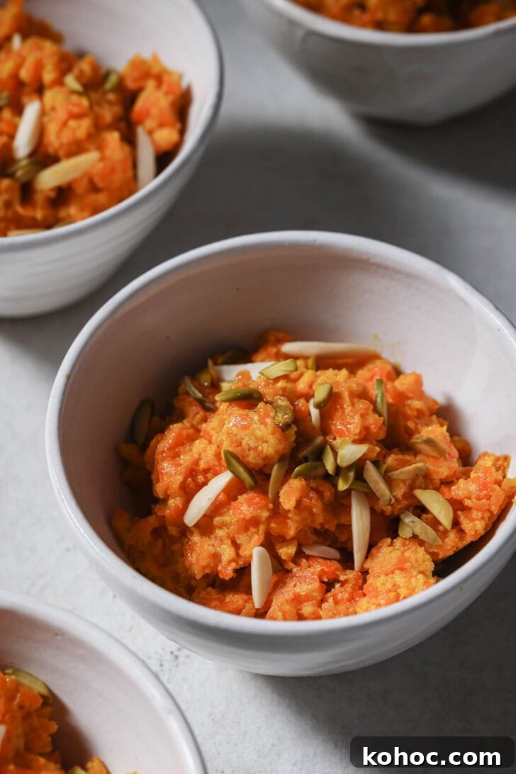 Close up of bowls of authentic Pakistani Carrot Halwa made on the stovetop garnished with slivered almonds and pistachios ready to be eaten.
