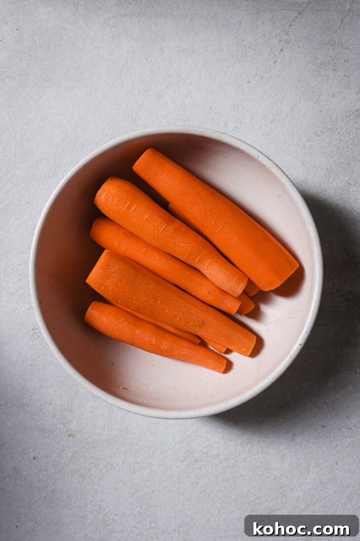 Carrots peeled and trimmed in a bowl ready to be used for Carrot Halwa.