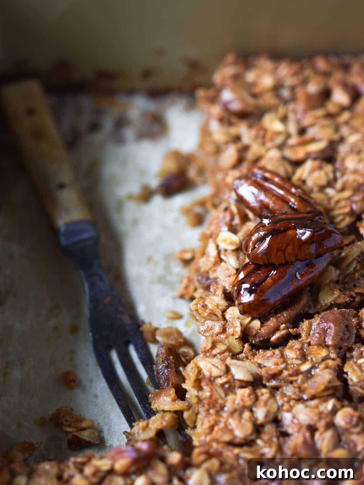 Pecan pie oatmeal in a pan, with a large piece taken out and a fork left in its place.