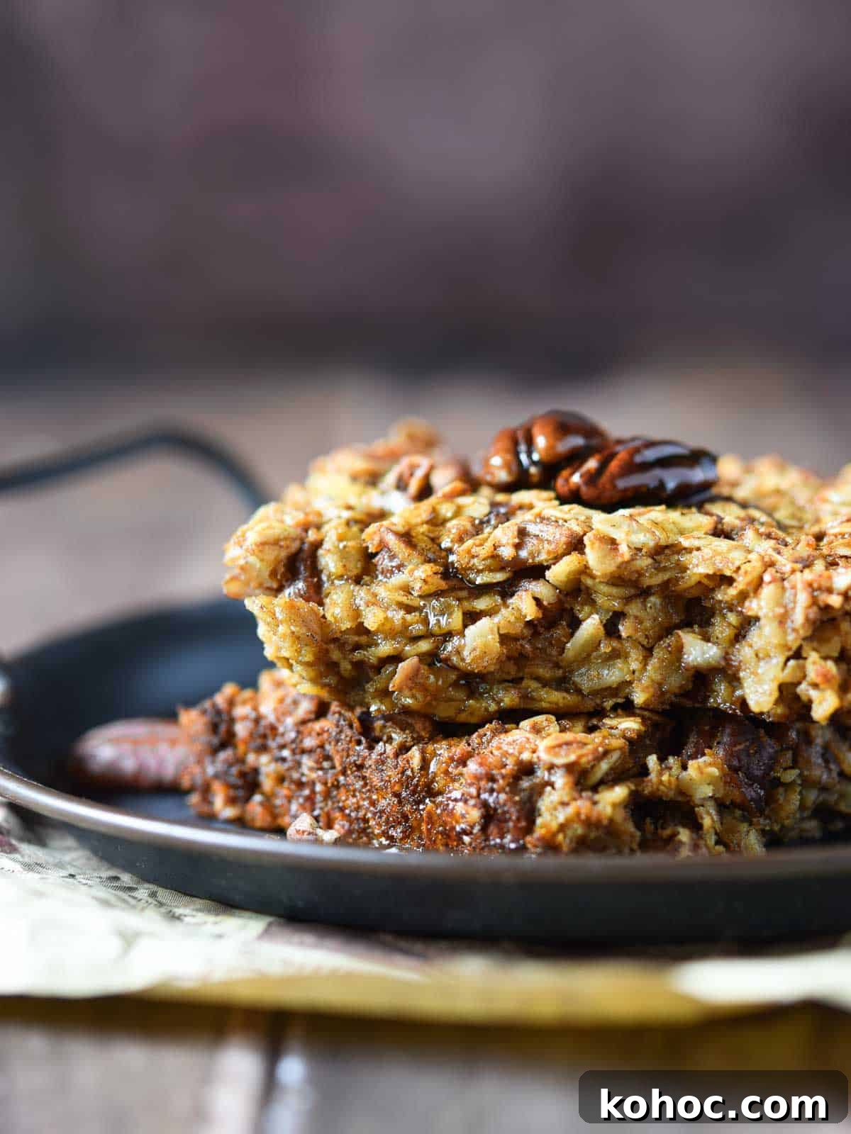 Pecan pie oatmeal stacked on a black tray with a brown background.