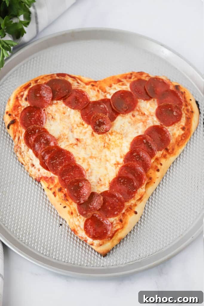 Make a Heart-Shaped Pizza at Home: Step-by-Step Recipe and Tips 2 A Heart Shaped Pizza on a pizza pan with a ring of pepperonis around the edge.
