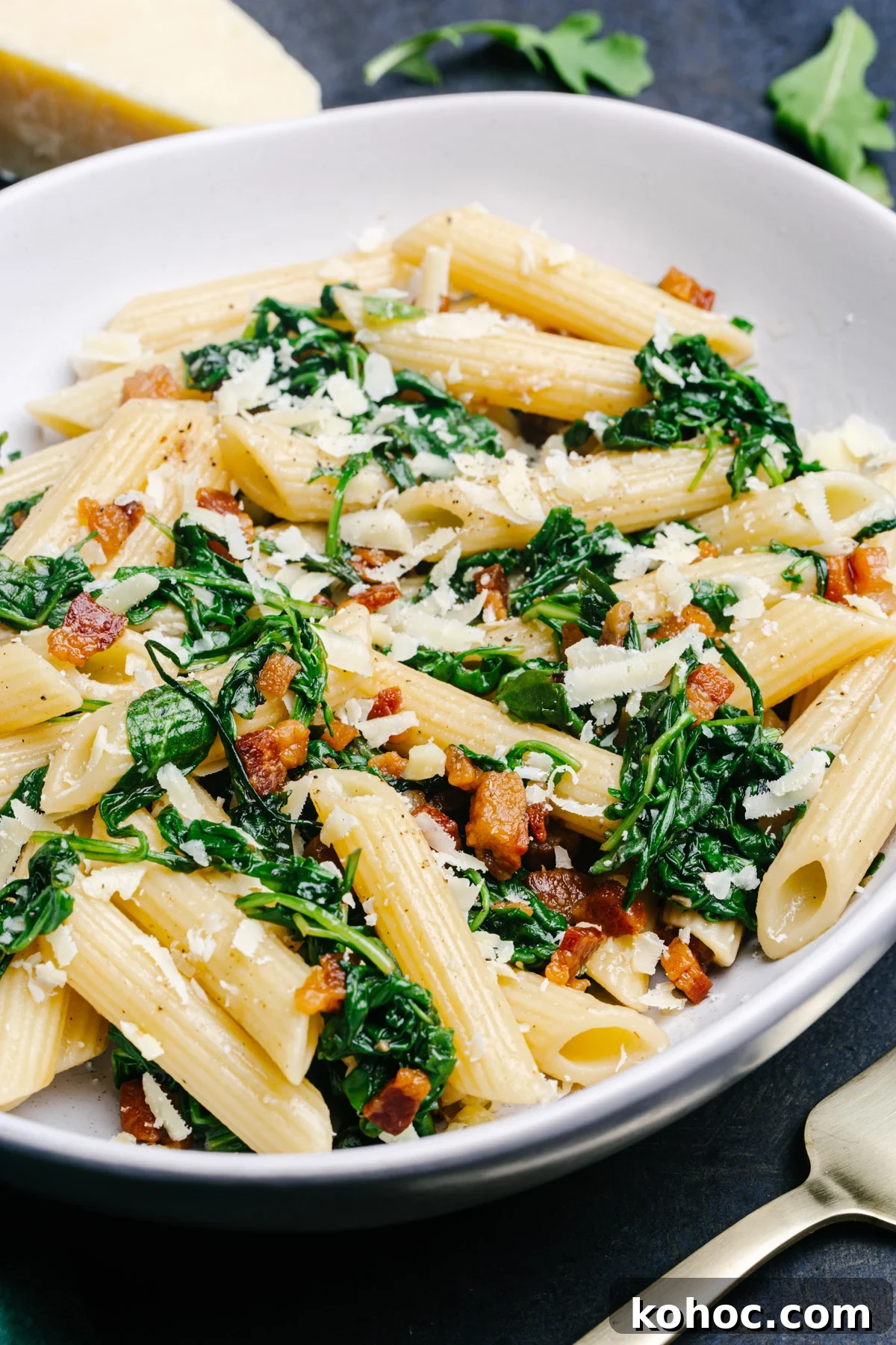 Creamy Pancetta Pasta with Parmesan and Peas 4 Pancetta Pasta served in a white bowl and photographed from an angle.