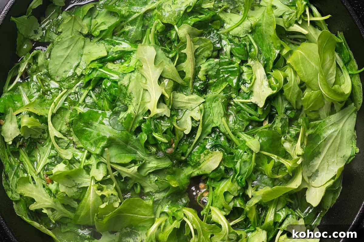 Creamy Pancetta Pasta with Parmesan and Peas 8 adding arugula to skillet.