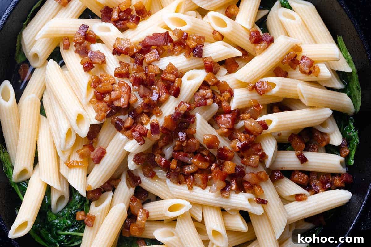 Creamy Pancetta Pasta with Parmesan and Peas 9 adding penne and cooked pancetta to skillet.