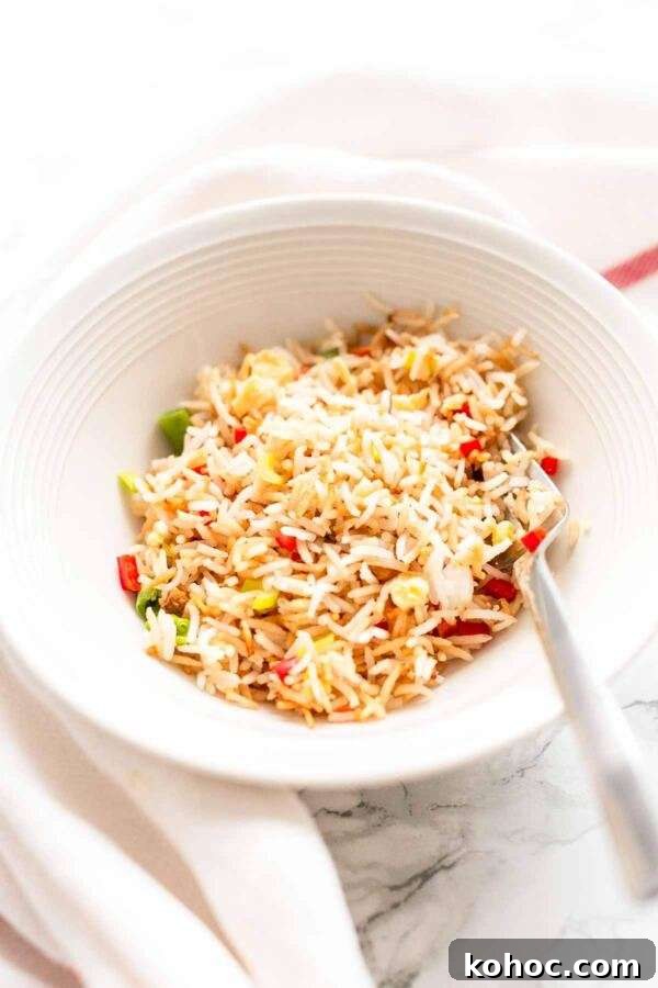 Crispy Air Fryer Fried Rice Recipe for Quick Weeknight Meals 11 White bowl filled with Air Fryer fried rice. Looks very tempting and tasty.