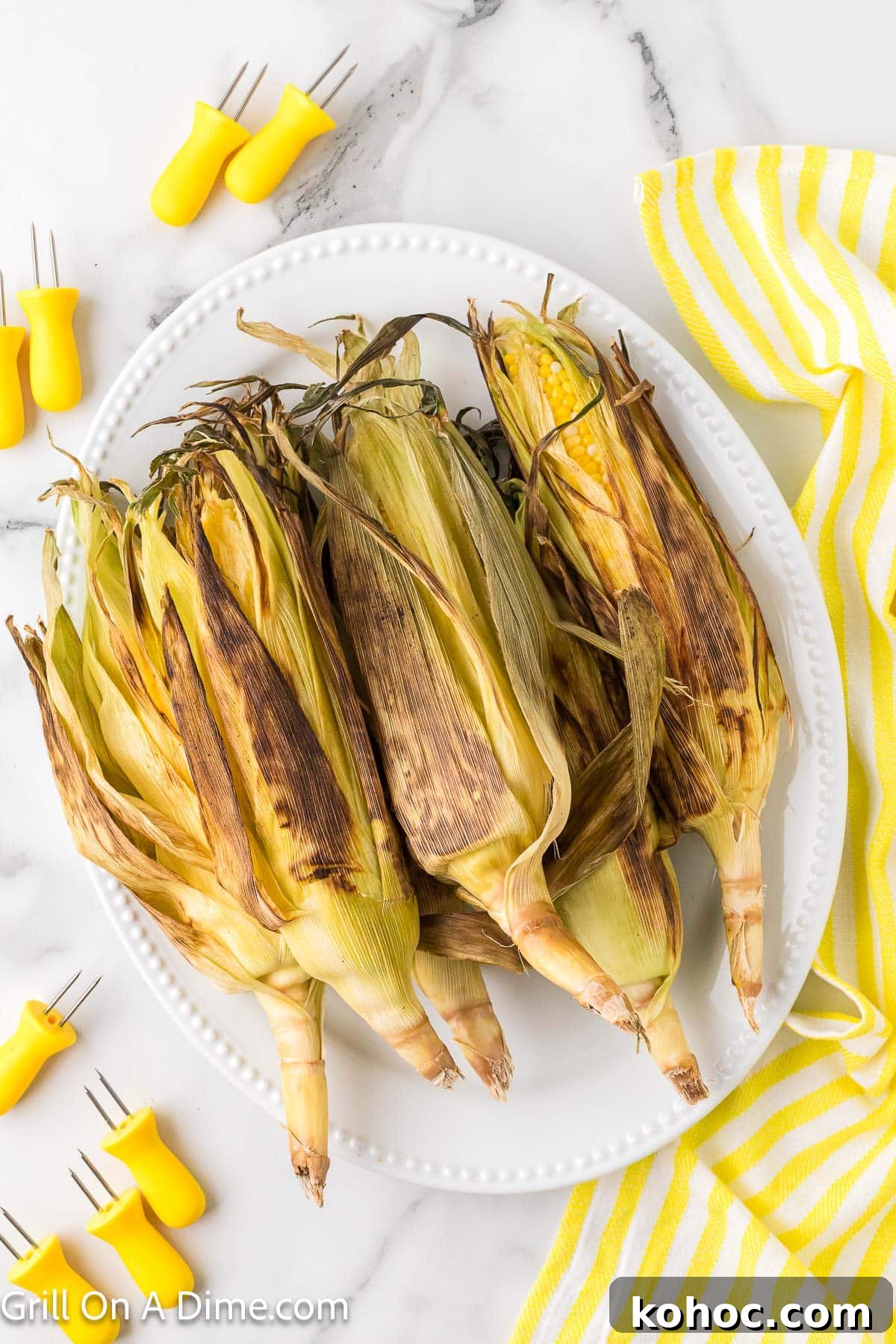 Blackstone Grilled Corn on the Cob in the Husk - Juicy BBQ Flavor 2 Corn on the cob in husk charred on a white platter