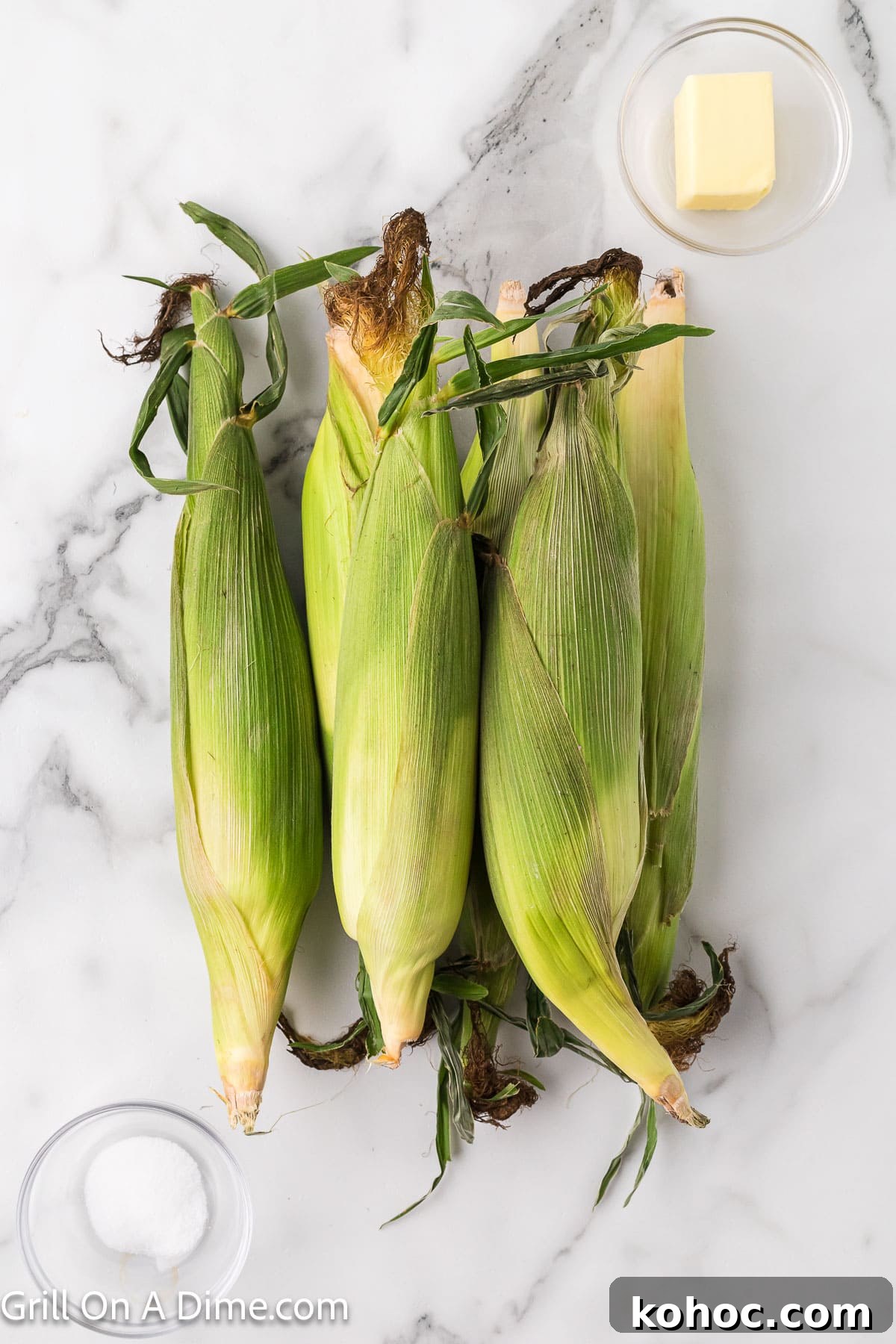 Blackstone Grilled Corn on the Cob in the Husk - Juicy BBQ Flavor 3 Corn on the cob with a small bowl of butter and salt