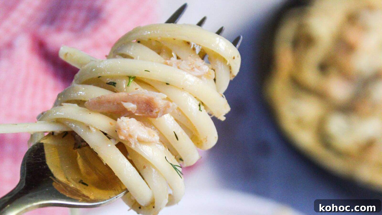 25 Skillet Meals Ready in 30 Minutes or Less 11 A close-up of spaghetti twirled on a fork with bits of crab meat and herbs, with more pasta and a dish in the blurred background.