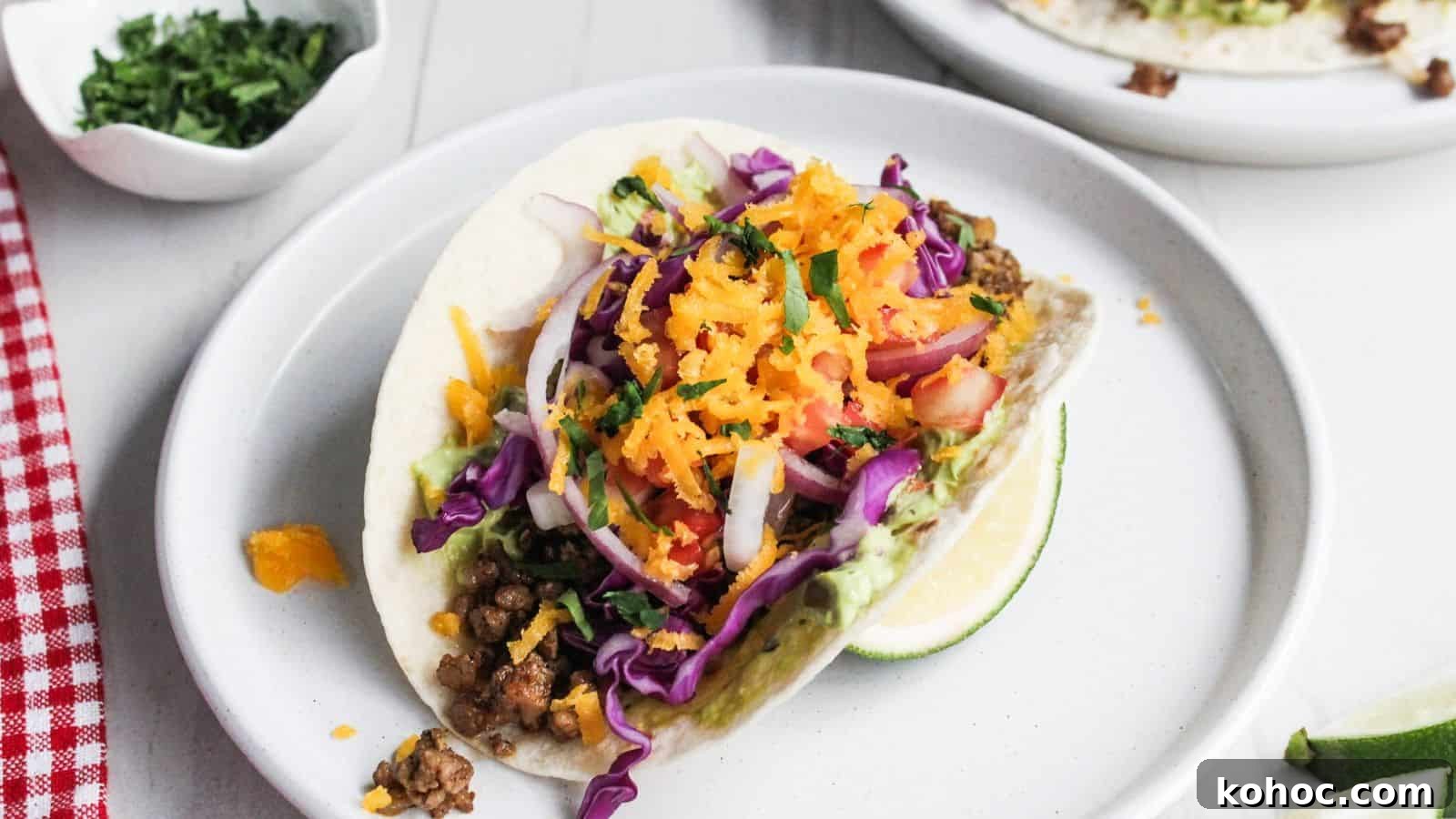 25 Skillet Meals Ready in 30 Minutes or Less 7 Two pork tacos on a white plate with lime wedges.