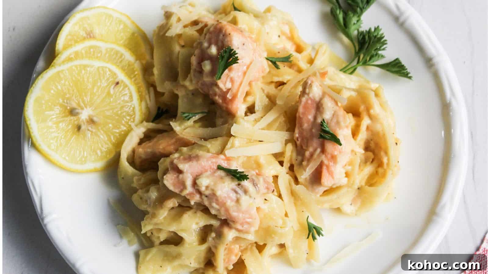 25 Skillet Meals Ready in 30 Minutes or Less 8 Salmon pasta Alfredo served on a white plate with lemon.