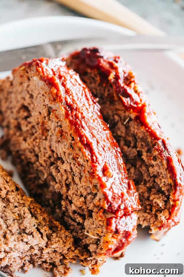 Make this juicy yet easy meatloaf recipe with a ketchup glaze, prepared with ground beef chuck and stuffed with cheese—it’s irresistibly good! Sliced meatloaf pieces on a white plate.