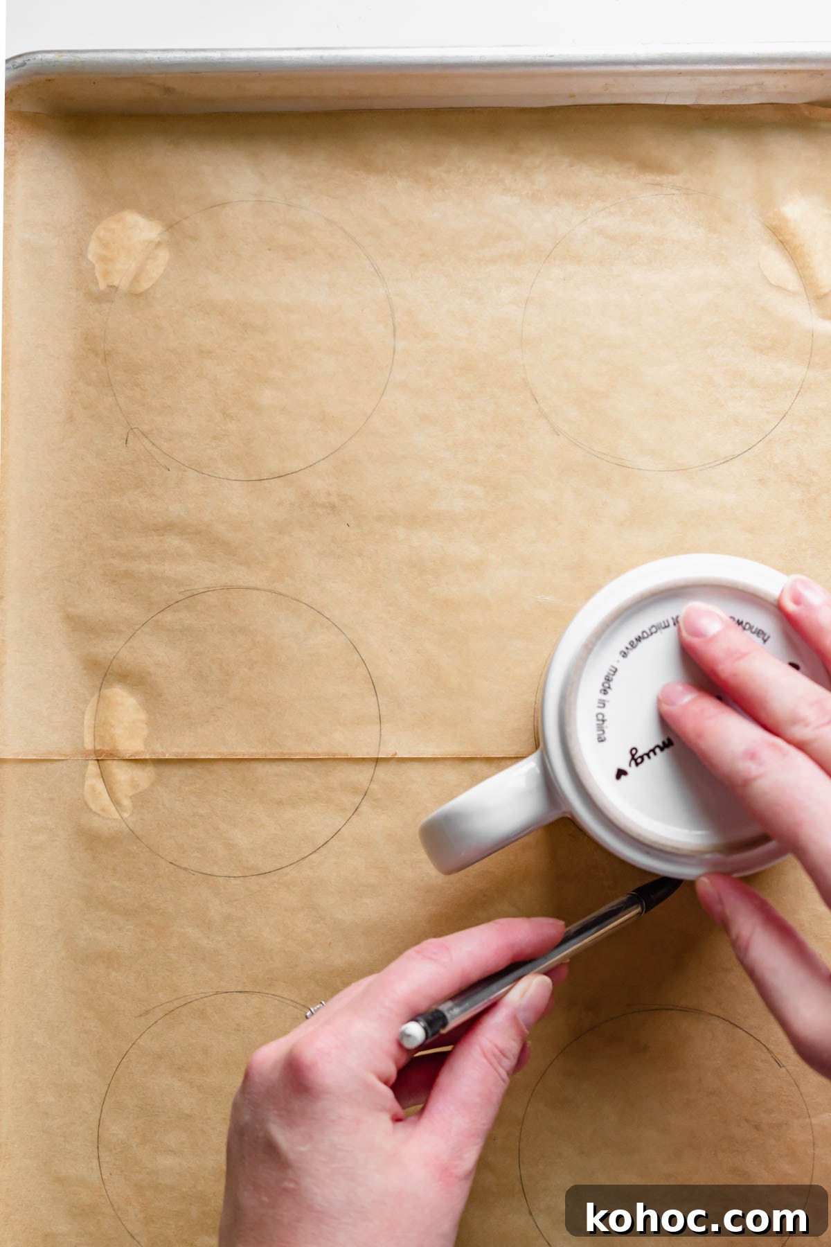 Tracing six rounds onto parchment paper using a coffee mug.