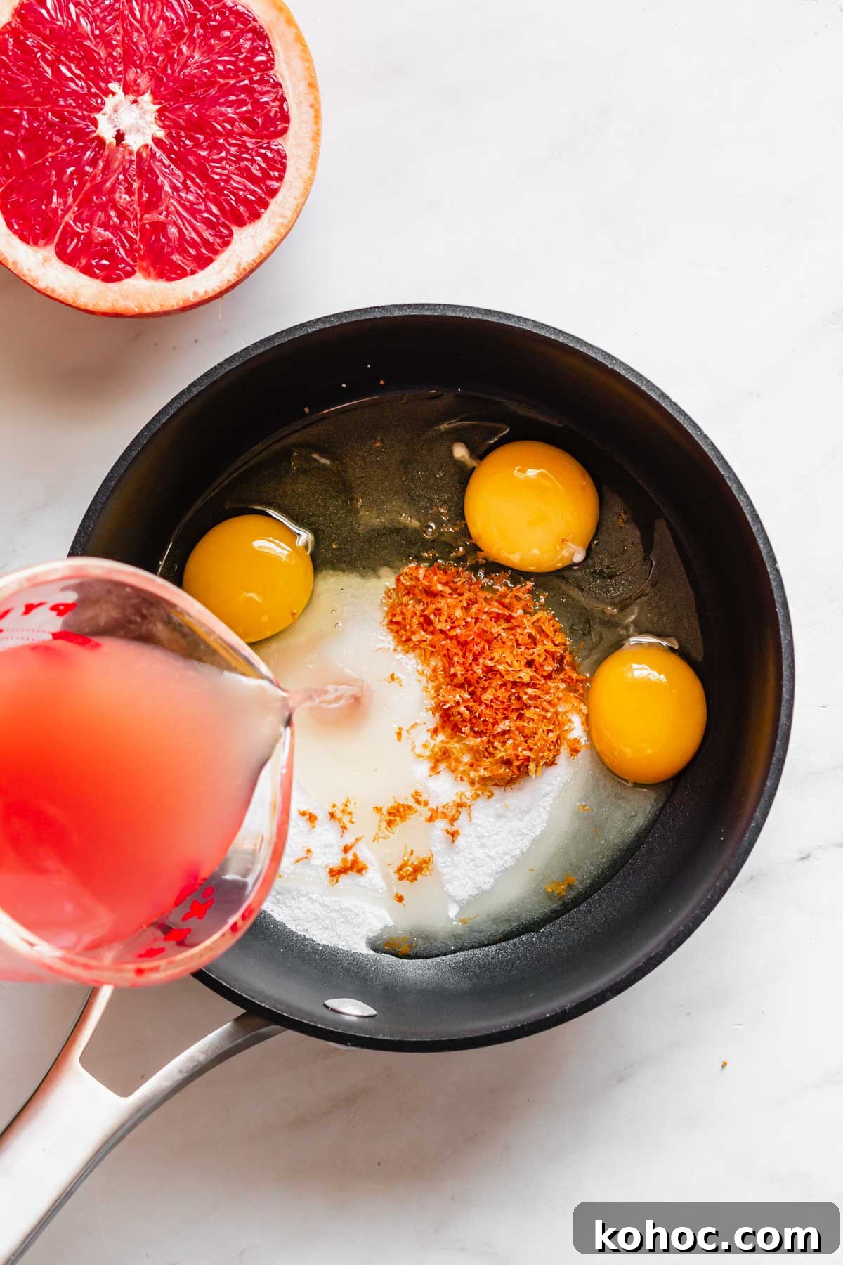 Grapefruit juice poured into a saucepan with the curd ingredients.
