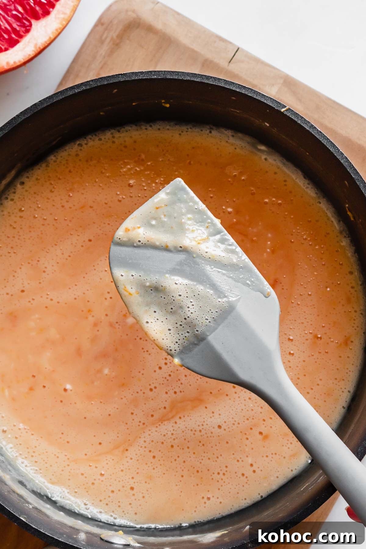 A spatula has a swipe of curd removed to show its thickness.