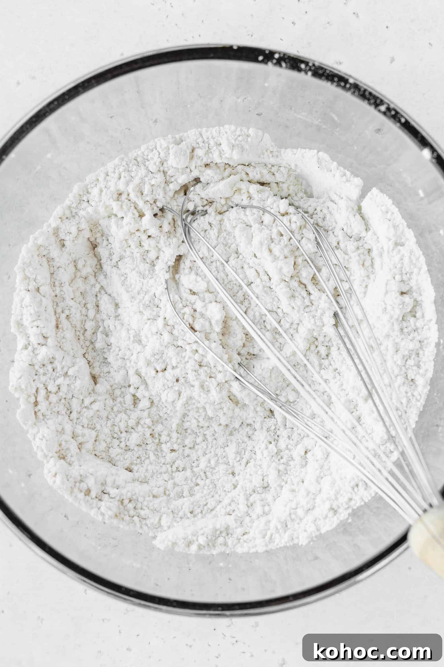 A bowl of flour and a whisk.
