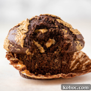 one chocolate peanut butter muffin with the muffin liner peeled partially off and a bite taken out