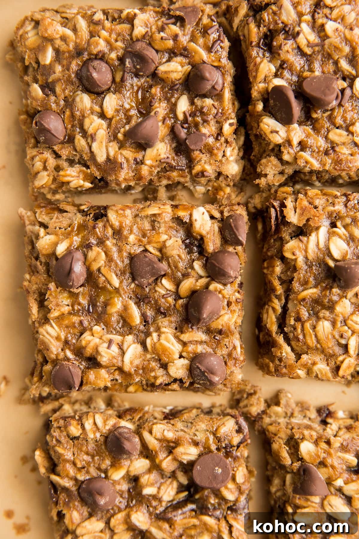 4-Ingredient Banana Oatmeal Bars Recipe for Quick Snacks 4 Slices of Oatmeal Bars on a sheet of parchment paper, ready to eat.