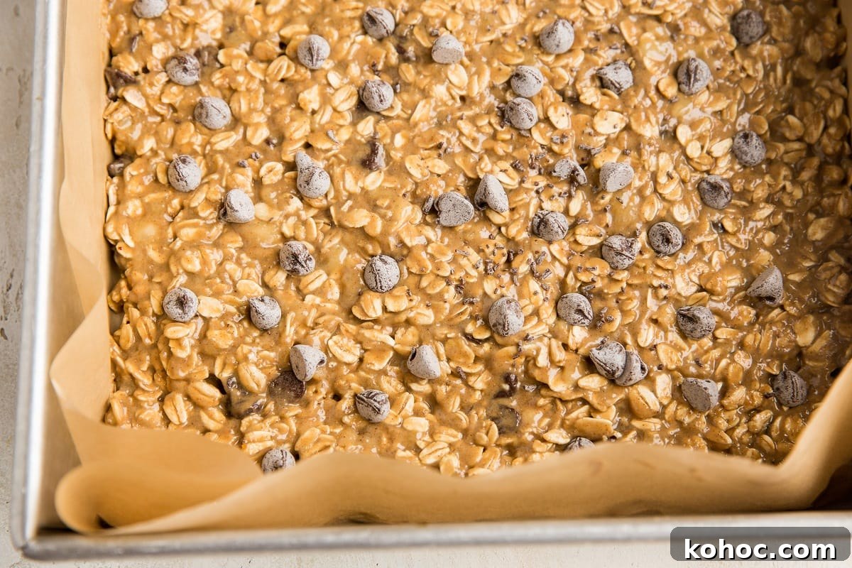 4-Ingredient Banana Oatmeal Bars Recipe for Quick Snacks 8 Oatmeal bar mixture in a parchment lined baking pan ready to go into the oven