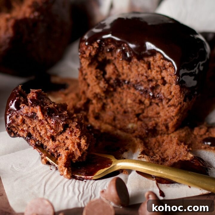 Someone using a fork to cut a bite from a health chocolate banana muffin.