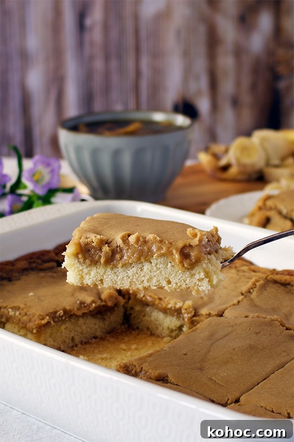 Banana Foster Butter Cake Recipe: Caramelized Bananas & Rum Glaze 3 Someone using a spatula to lift a piece of St. Louis Gooey Butter Cake from a baking dish.