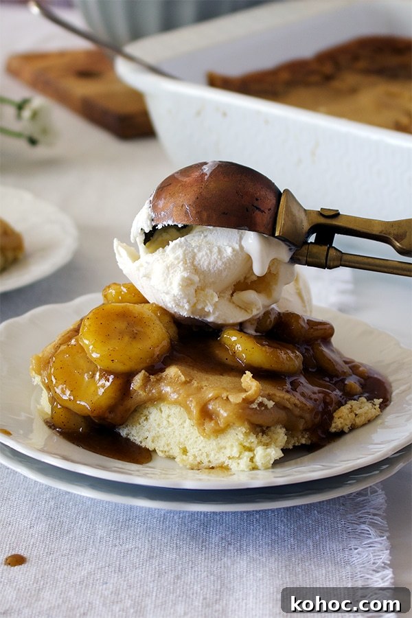 Banana Foster Butter Cake Recipe: Caramelized Bananas & Rum Glaze 6 Someone using an ice cream scoop to top a piece of Bananas Foster Cake with vanilla ice cream.
