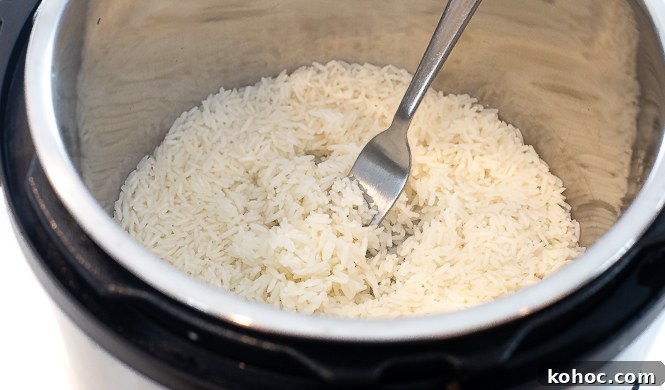 Perfect Instant Pot Fried Rice Recipe for Quick Weeknight Meals 6 Rice being fluffed with a fork in an instant pot.