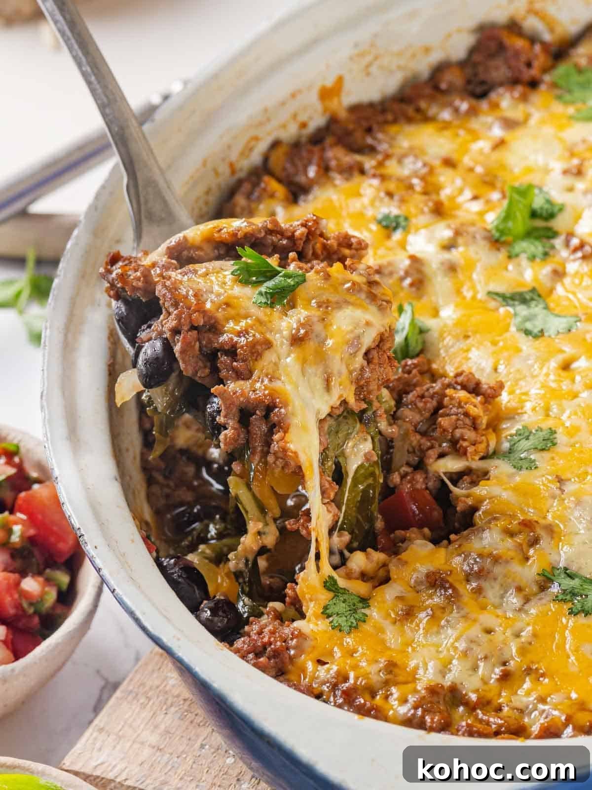 Cheesy Taco Casserole Bake with Ground Beef and Corn 2 taco bake being served with cheese pull.