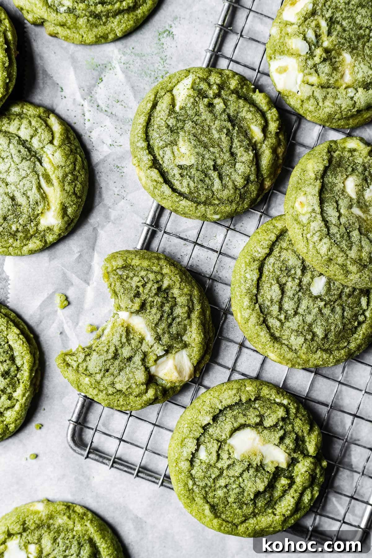 Matcha White Chocolate Cookies Recipe for Soft, Chewy Treats 2 Matcha cookies on a metal wire cooling rack and white parchment paper.