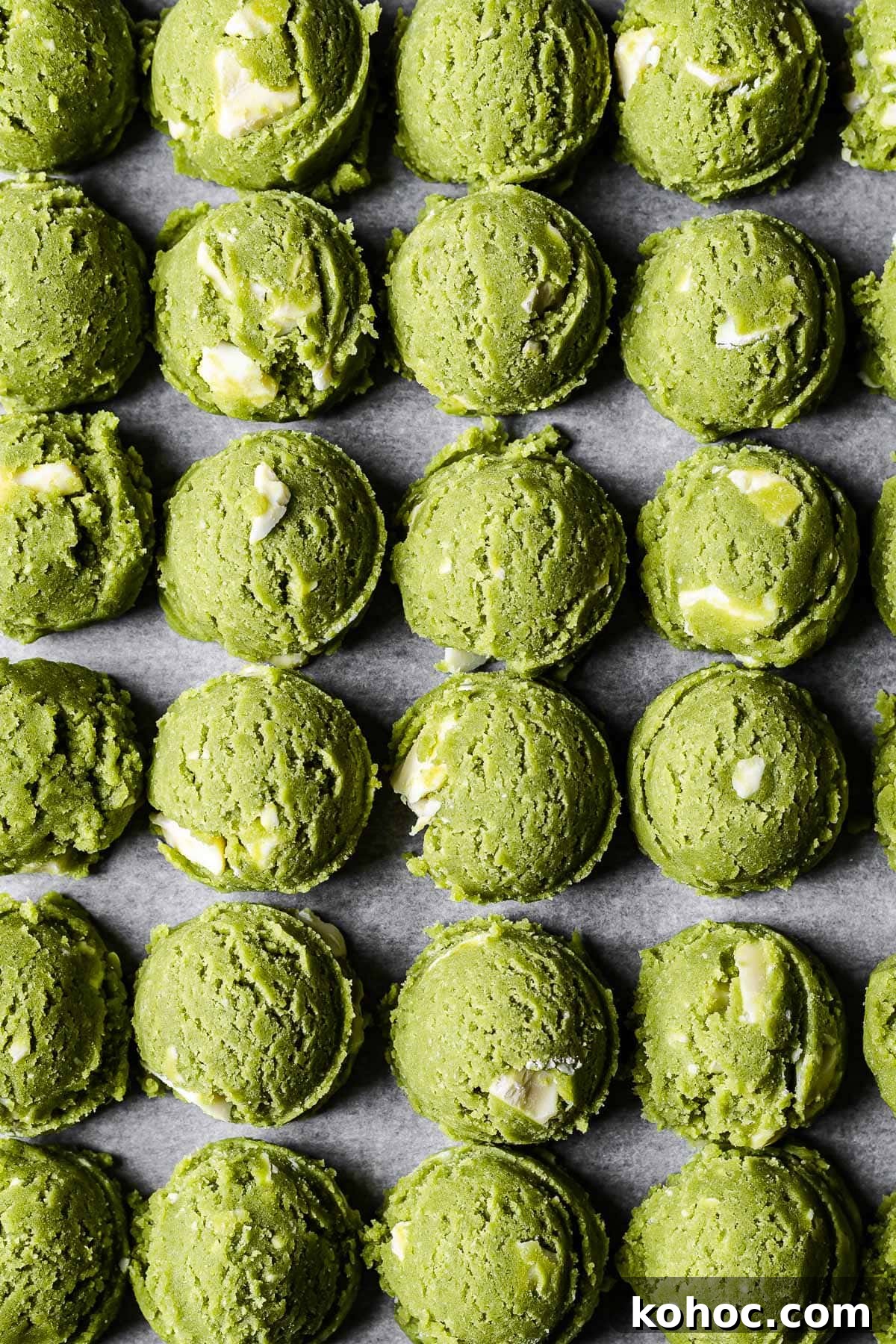 Matcha White Chocolate Cookies Recipe for Soft, Chewy Treats 9 Scoops of vibrant green matcha chocolate chip cookie dough lined up in rows.
