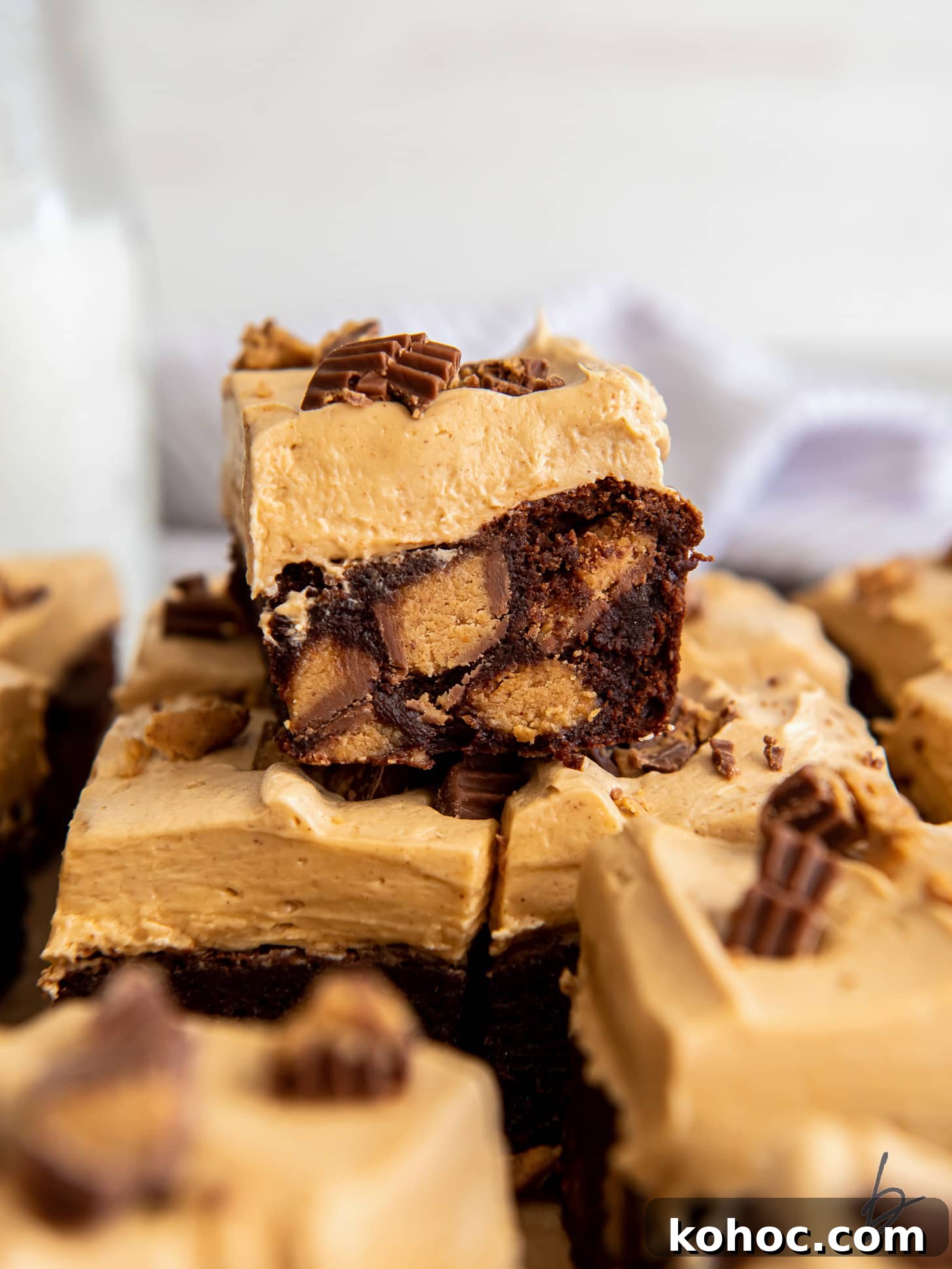 Frosted Peanut Butter Brownies Recipe — Rich Fudgy Chocolate Bars 2 frosted peanut butter brownie with peanut butter cups inside.