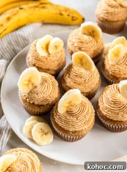 Banana cupcakes topped with peanut butter frosting and a banana slice for garnish.