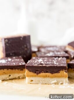 side of peanut butter chocolate bar showing layers of shortbread crust, peanut butter filling and chocolate topping