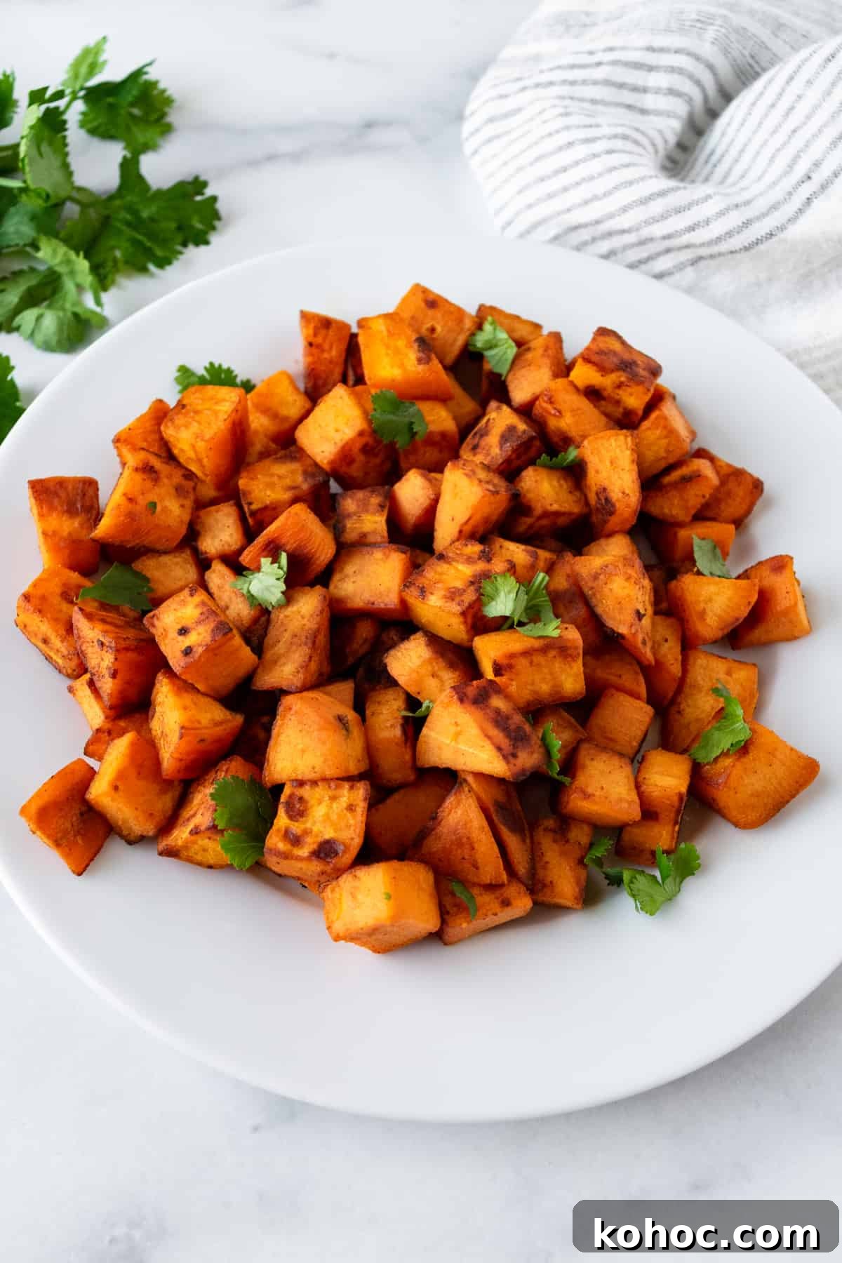 Crispy Sautéed Sweet Potatoes with Garlic and Herbs 5 Sautéed Sweet Potatoes on a white plate.