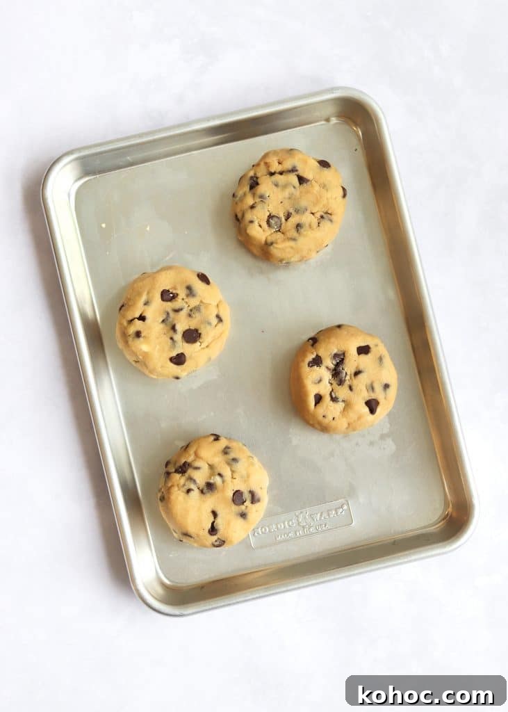 Thick Chewy Chocolate Chip Cookie Recipe 3 Formed discs of cookie dough on a light baking sheet