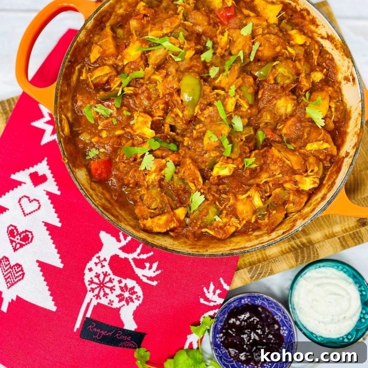 leftover christmas turkey curry in a skillet pan with cranberry sauce and mint yogurt dip