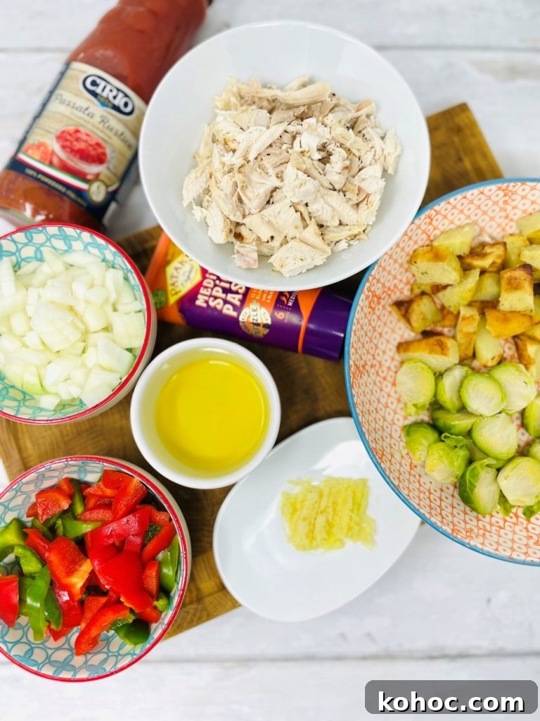 Leftover Turkey Curry Recipe for Quick Weeknight Meals 3 leftover turkey curry ingredients on a board - leftover turkey, curry paste, leftover sprouts and roast potatoes, chopped pepper, diced onions, chopped garlic and ginger and a jar of tomato pasatta