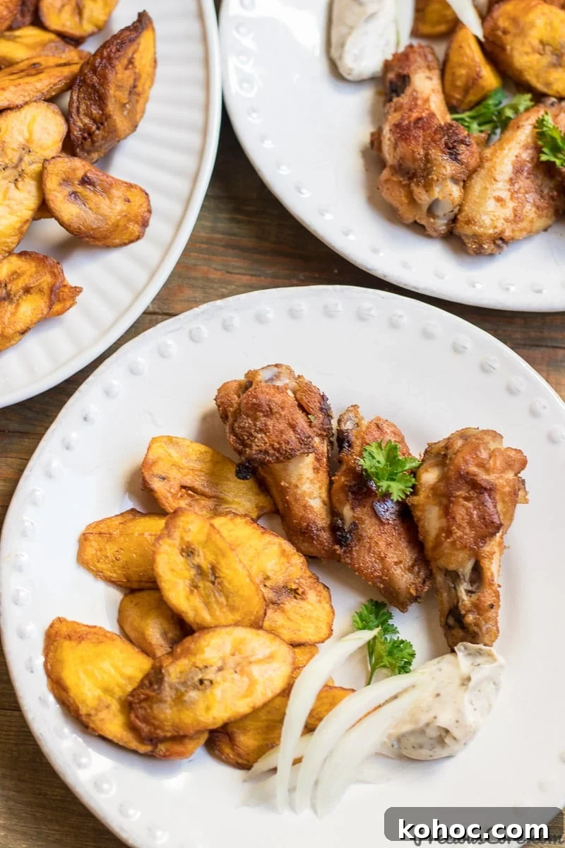 Crispy Sweet Fried Plantains (Tostones Maduros Recipe) 7 Sweet fried plantains on a white plate with oven grilled chicken wings.
