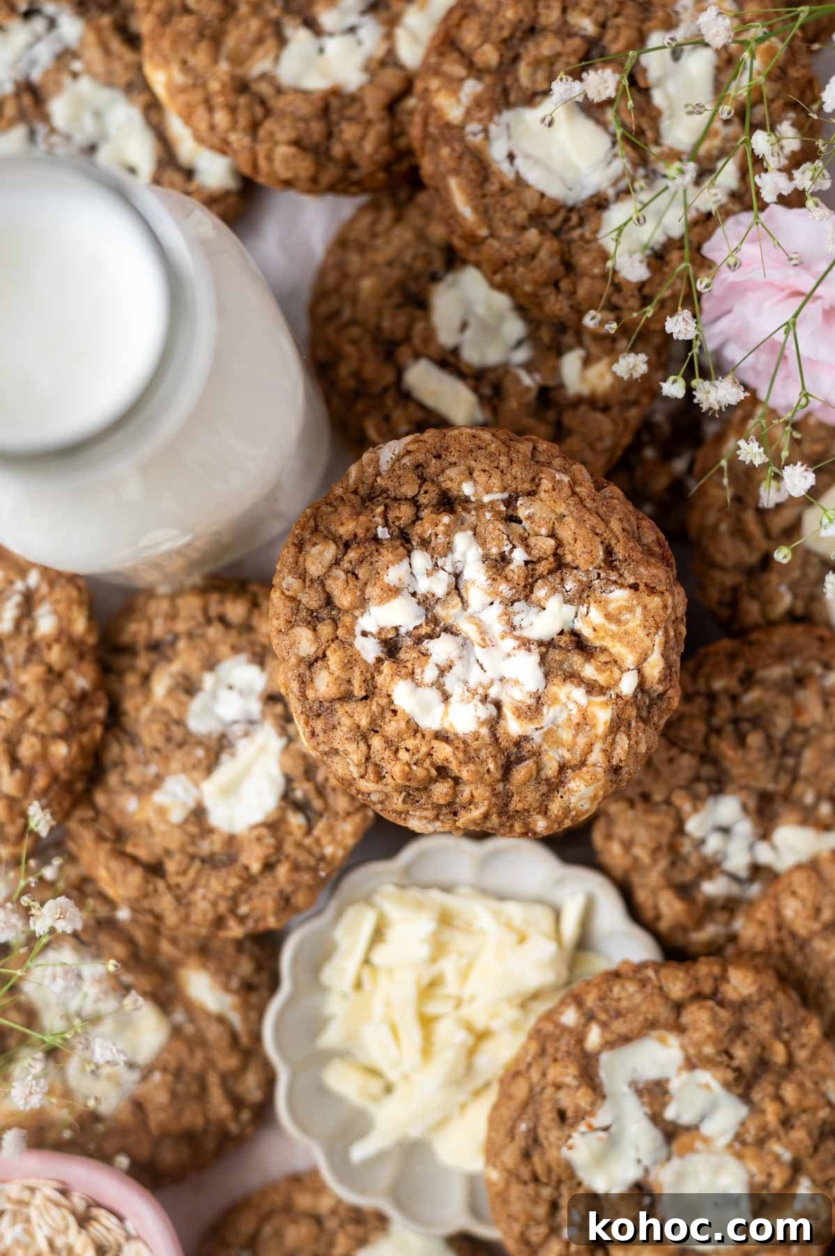 Chewy Brown-Butter Oatmeal Cookies with Sea Salt 9 a pile of brown butter oatmeal cookies with a glass of milk and a bowl of white chocolate